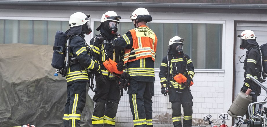 Zwei Feuerwehrmänner schneiden mit hydraulischem Rettungsgerät ein Auto auf